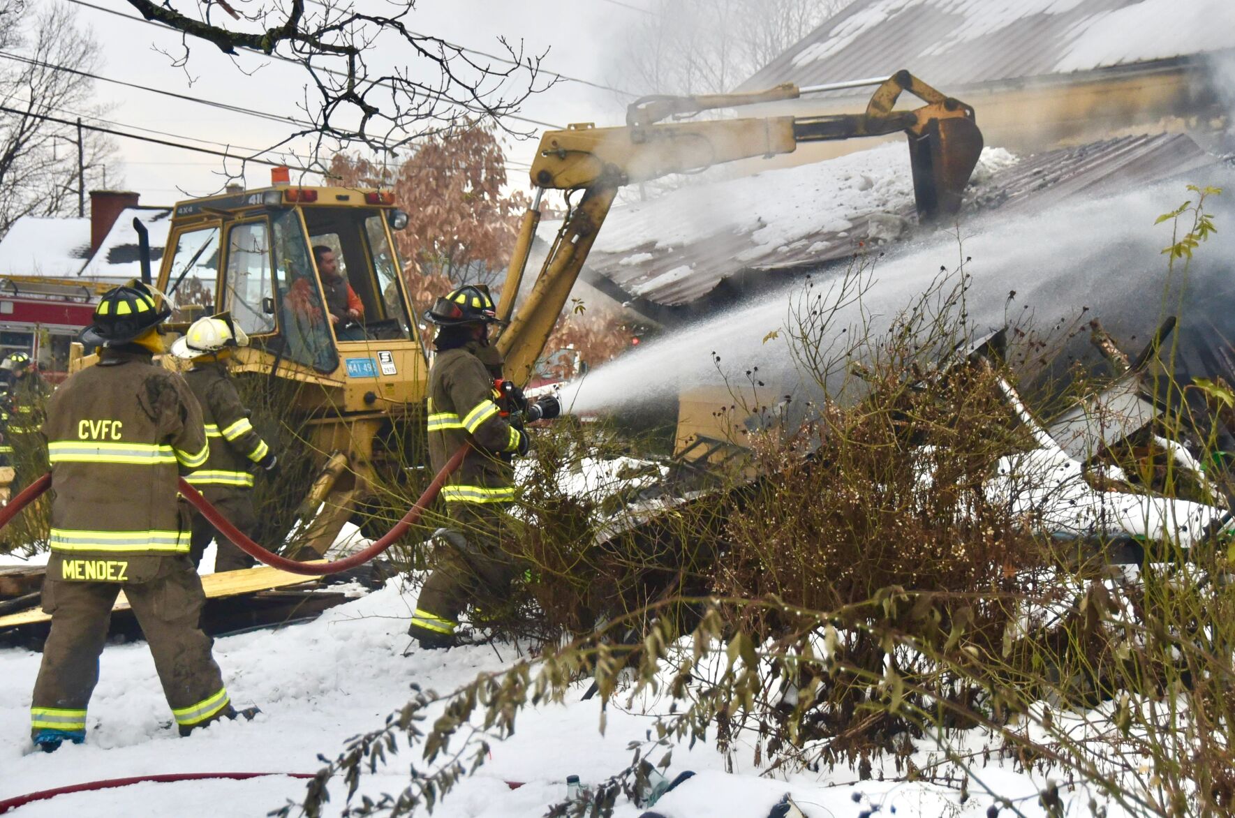 Firefighters spray water on burning home